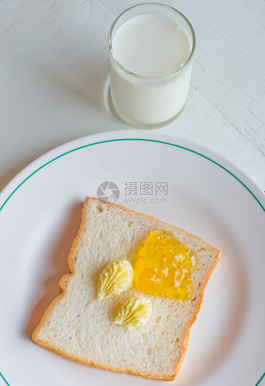 白盘上的面包黄油果酱甜点玻璃小吃食物盘子黄油牛奶早餐饮食白色图片