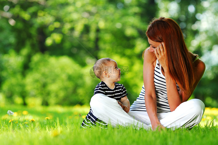 母亲和女儿在绿草上孩子婴儿快乐喜悦女士夫妻男生乐趣场地花朵图片