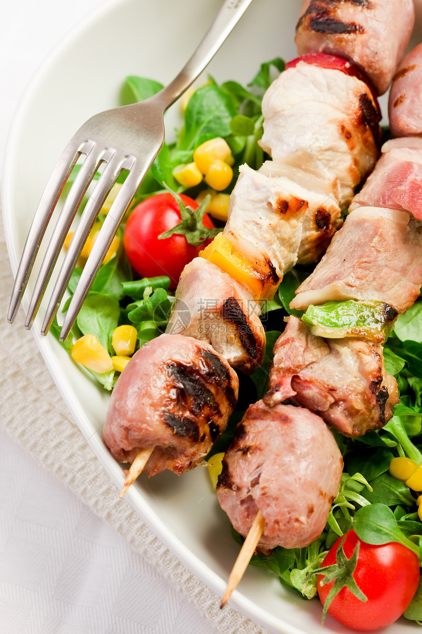 白桌上的肉类扭曲器烤串猪肉胡椒西红柿玉米健康饮食宏观食物照片沙拉图片
