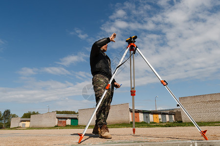 测量员三脚架建筑工地土地测量员背景