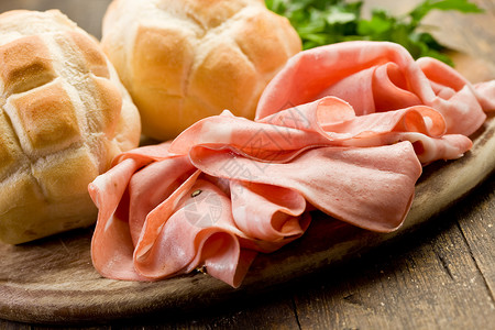 弗朗西斯·培根Mortadella和面包在购物板上香肠粉色小吃火腿饮食熏肉香菜美食猪肉面包背景