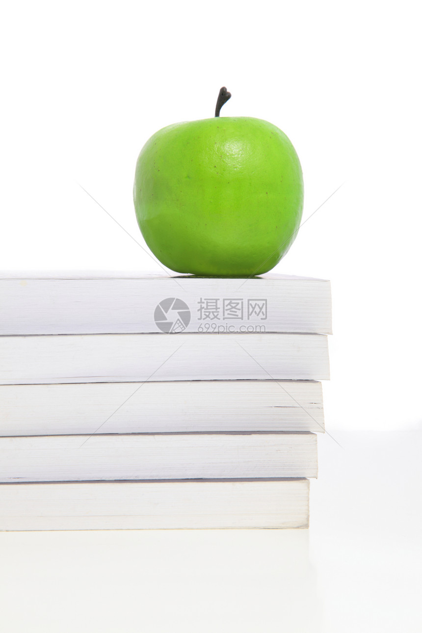 堆叠在书本上的绿苹果图片
