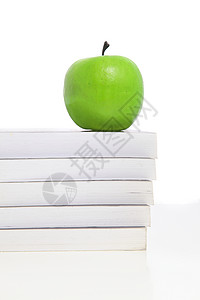 堆叠在书本上的绿苹果背景图片