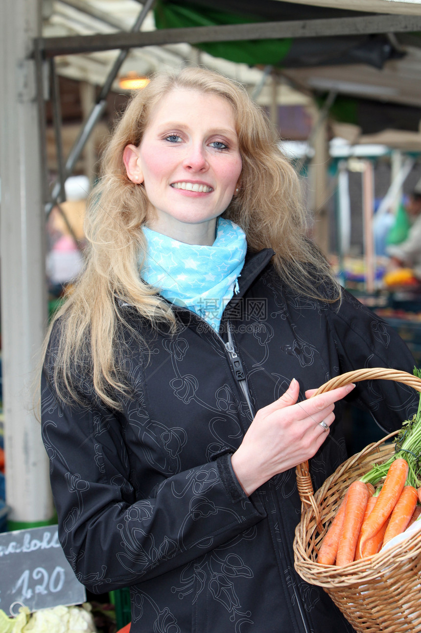 女人在市场上买蔬菜的图片