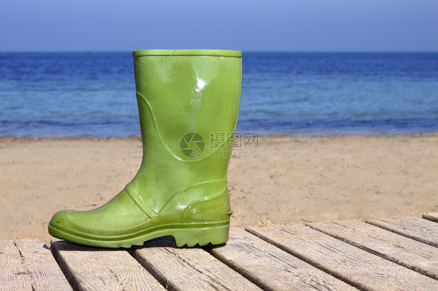 海滩上不幸渔夫比喻上的绿靴子木头海岸季节支撑晴天海景土壤太阳假期海洋图片