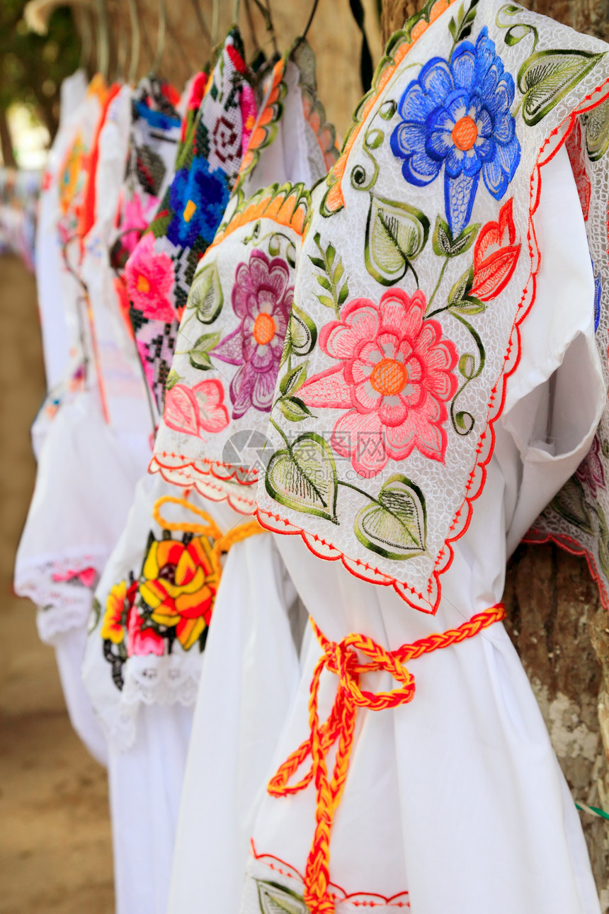 玛雅妇女穿着刺绣Yucatan墨西哥纪念品工艺裙子手工织物小贩销售衣架衣服刮刀图片