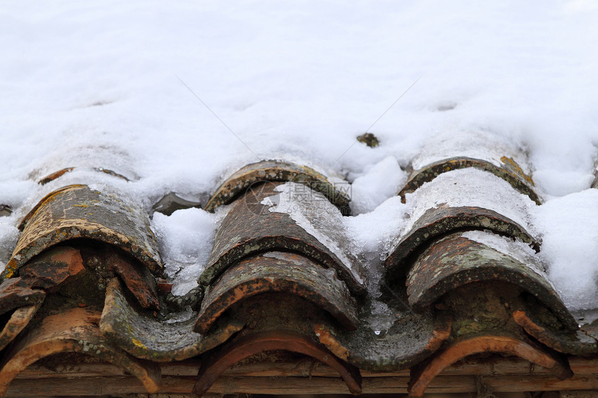 年老的泥土屋顶瓷砖在冬季雪下下下雪黏土住宅橙子建筑学财产框架滑雪石头房子城市图片