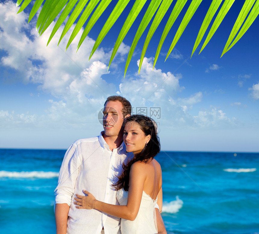 在蓝海度假中 情侣相爱的拥抱妻子海滩裙子幸福婚礼女性假期恋人婚姻庆典图片