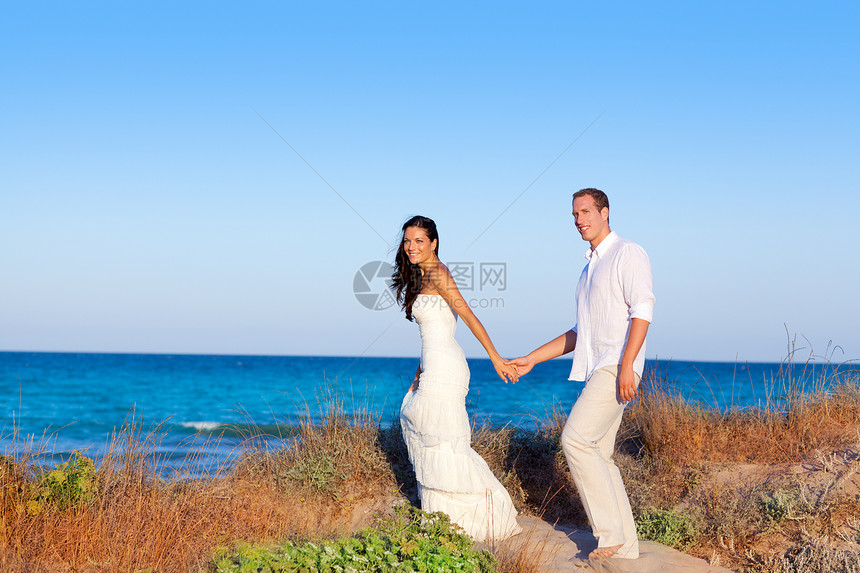 在地中海海滩上相爱的情侣女孩假期套装情感蓝色婚礼裙子丈夫男人男性图片