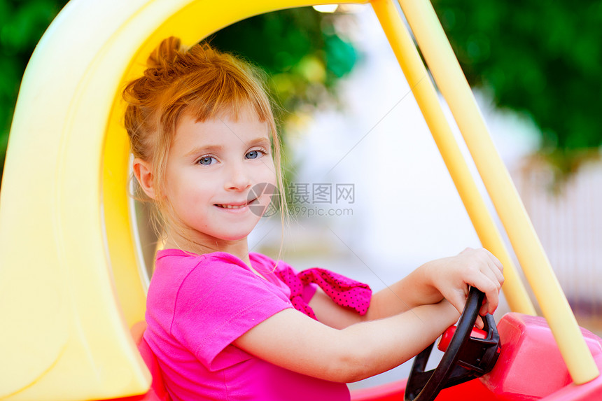 驾驶玩具车的金发女孩享受喜悦学校女性车轮边缘操场家庭童年生活图片