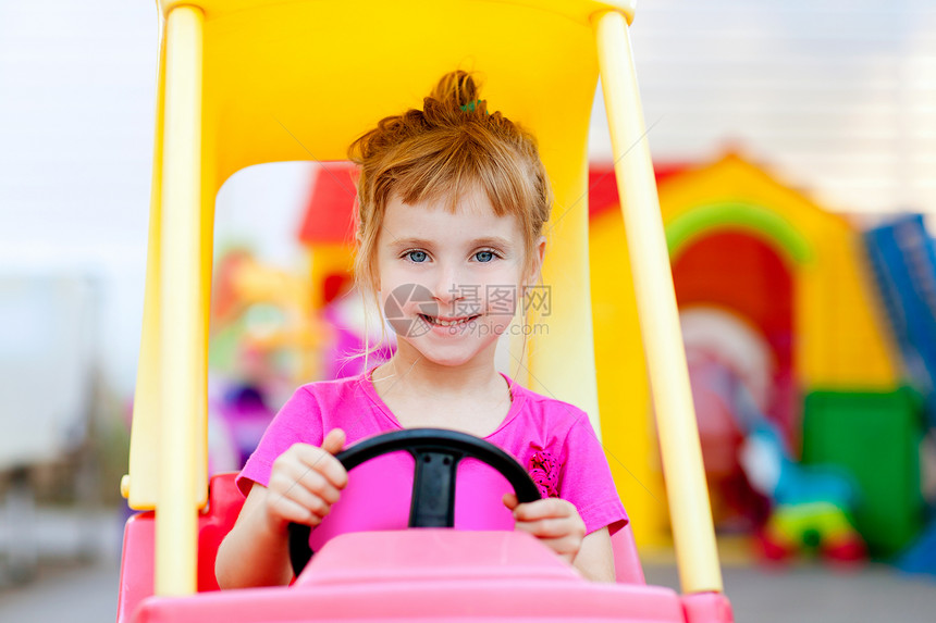 驾驶玩具车的金发女孩学校喜悦微笑边缘车轮生活女儿孩子女性童年图片