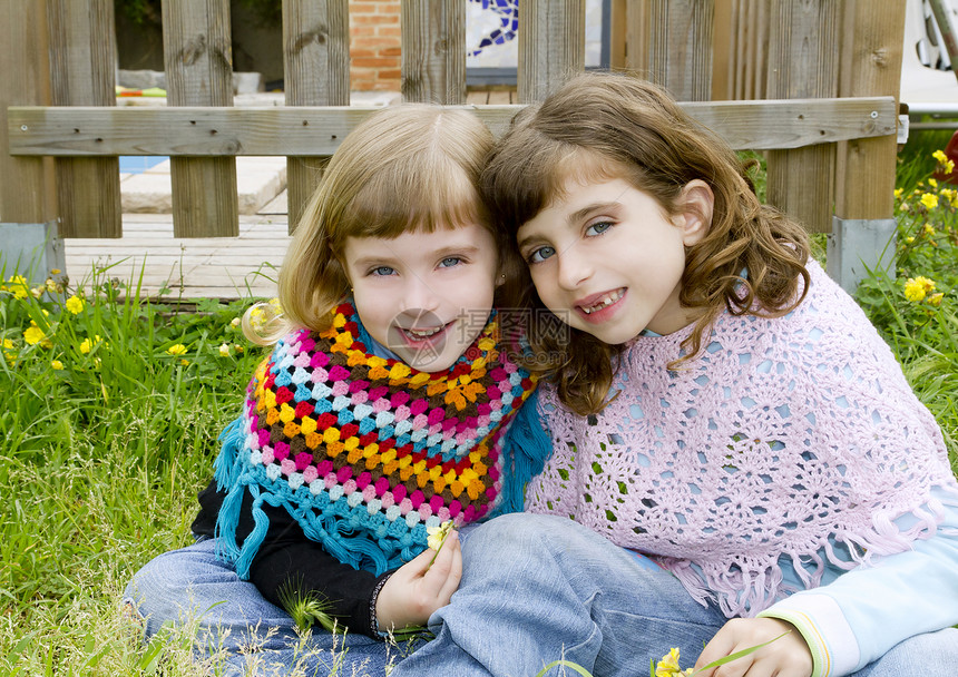 姐妹女童在草地春篱笆中微笑图片