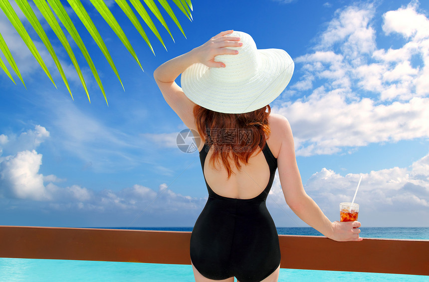 女人看鸡尾酒热带沙滩情调栅栏闲暇饮料游泳衣树叶海岸假期通体苏打图片