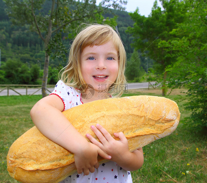 拥有大面包幽默的女童饥饿儿童蓝色快乐童年孩子手势小吃女性乐趣微笑金发图片