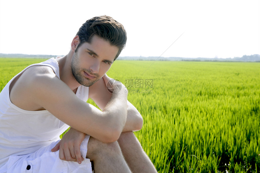 在绿色草原上快乐的青年男子户外发型植物晴天男生闲暇草地喜悦微笑蓝色场地图片