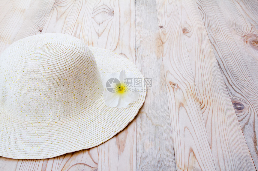 带有白花的沙帽装饰海滩服装植物配饰地面花朵女孩纺织品木头图片