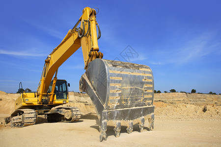 沙采石场上的挖挖机黄色车辆背景图片