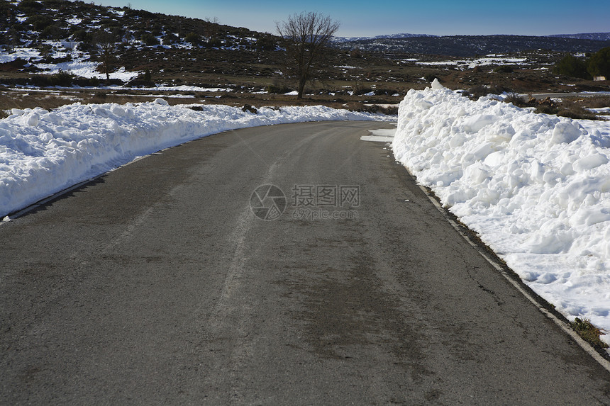 两边边界都有积雪的沥青路曲线图片