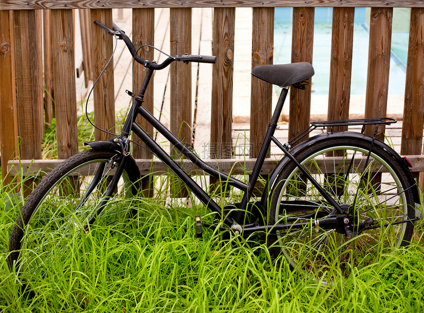 年老于木篱笆上的黑鬼自行车图片