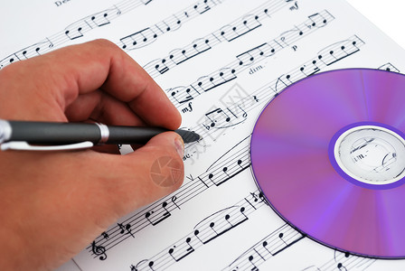 光盘手写字cd或 dvd 驱动器和乐笔床单圆圈作曲家艺术写作记录手指光盘宏观技术背景