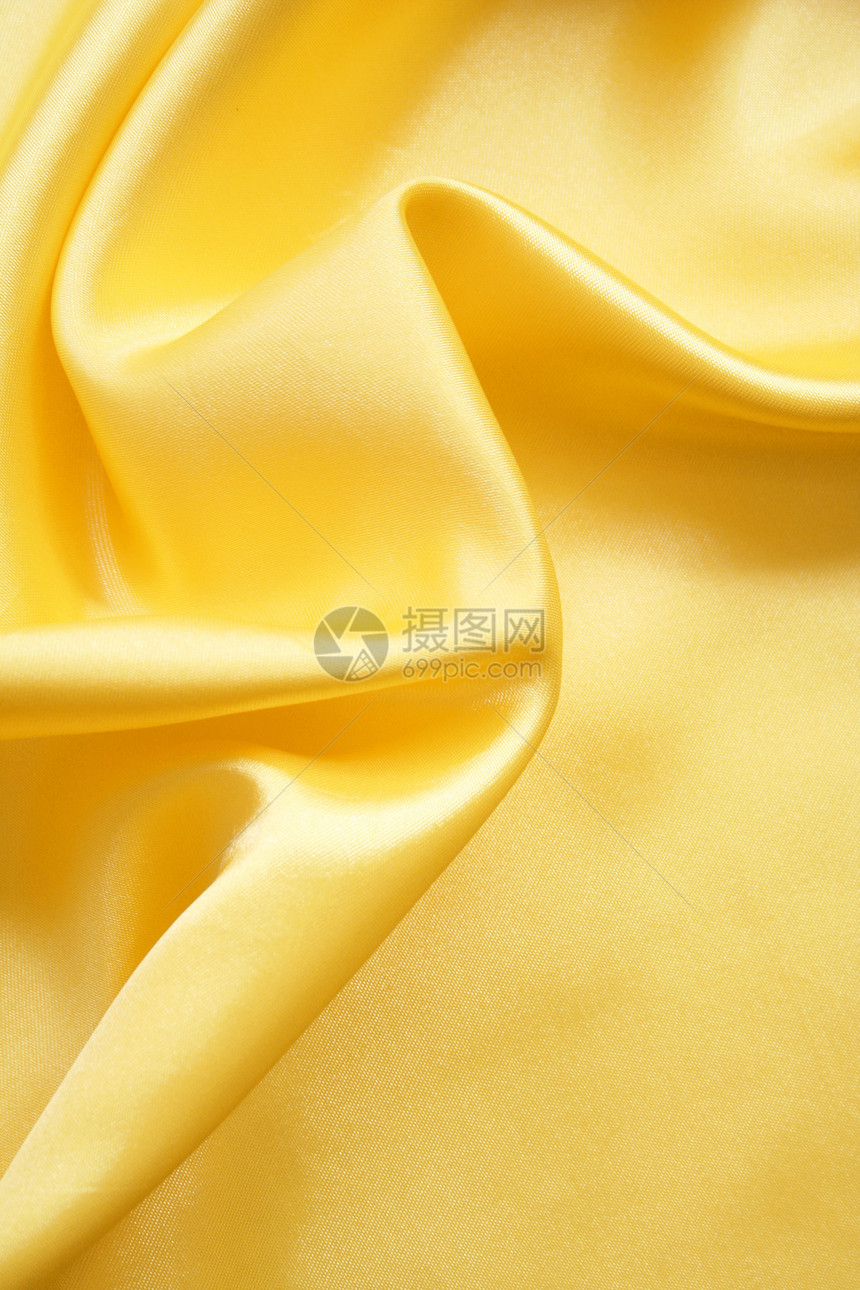 平滑优雅的金色丝绸可用作背景折痕织物布料涟漪曲线投标海浪黄色纺织品材料图片