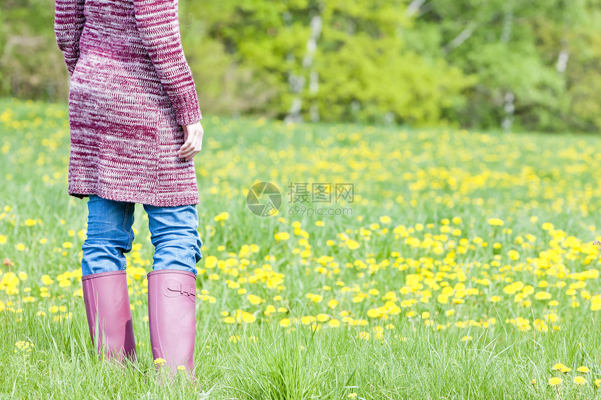 妇女穿着橡胶靴在春草草地上穿橡皮靴的情况女士牛仔布牛仔裤女性外观毛衣鞋类成人紫色裤子图片