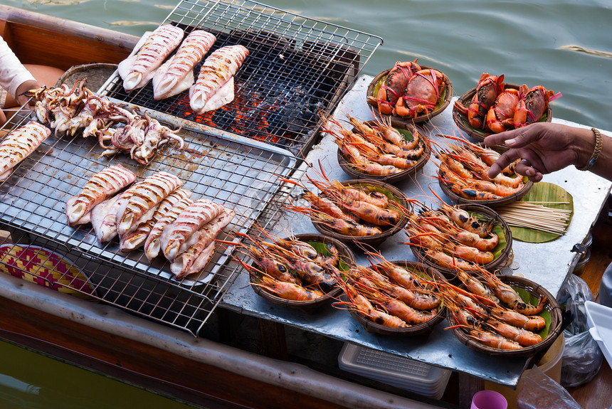 销售新鲜鱿鱼和拖网的泰国传统水市场船图片