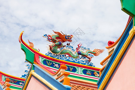 在圣殿屋顶的多彩中国龙雕像背景图片