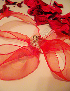 红丝带和花瓣钻石环背景图片