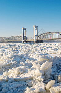 在阳光明媚的天气下 在冰冻河流上架桥漂移运输历史性蓝色天空建筑学季节铁路雪景照片背景图片