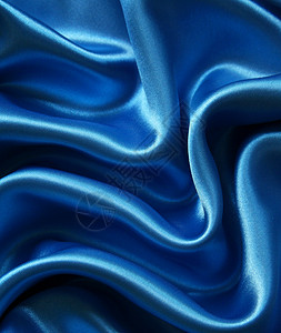 平滑优雅的深蓝丝绸可用作背景丝绸折痕海浪投标曲线织物材料纺织品布料银色背景图片