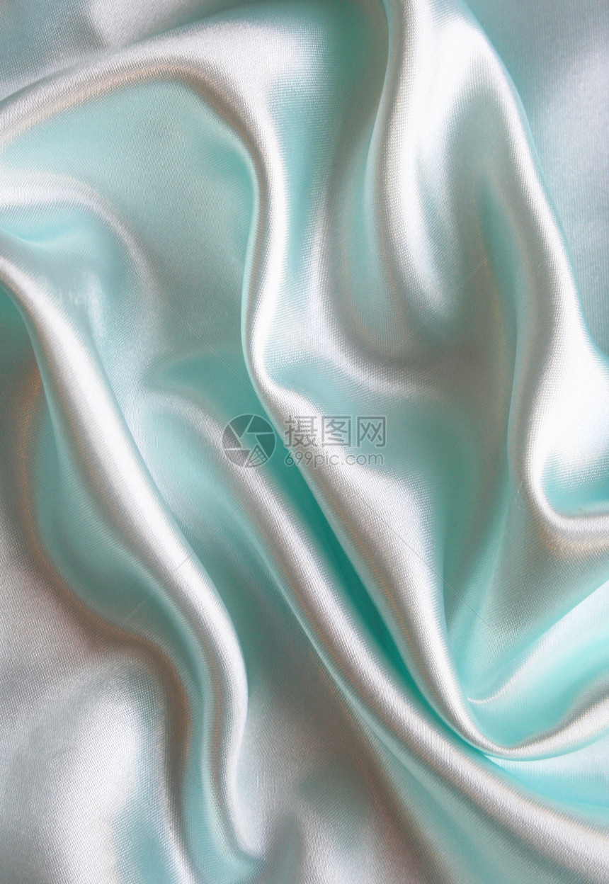 平滑优雅的蓝色丝绸作为背景海浪织物生产曲线银色版税感性布料材料折痕图片