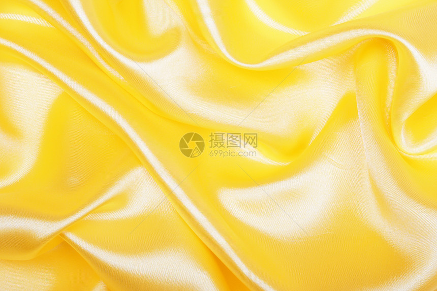 平滑优雅的金色丝绸作为背景海浪曲线涟漪投标纺织品材料黄色折痕织物布料图片