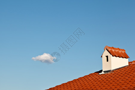 白色屋顶美丽的云和多尔默窗口 带有红色铁踏屋顶背景