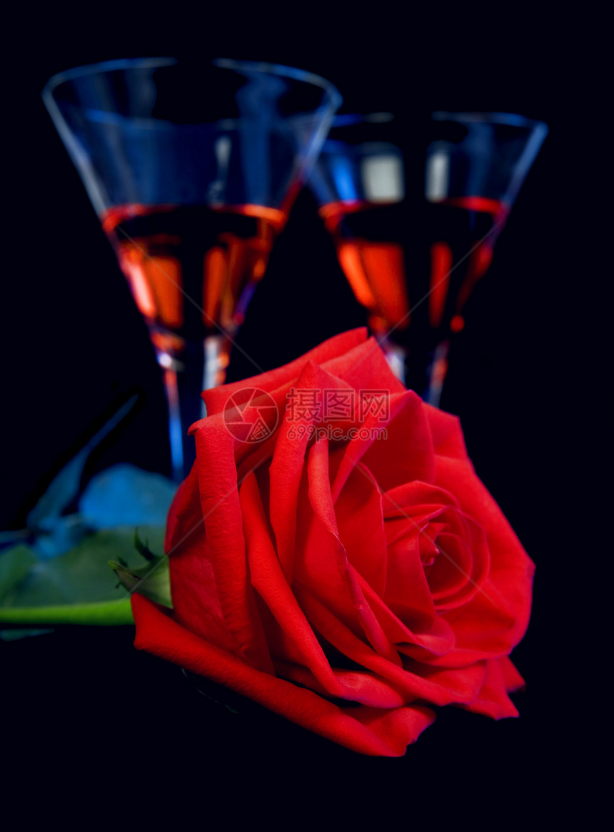 红玫瑰和酒杯中的美酒图片