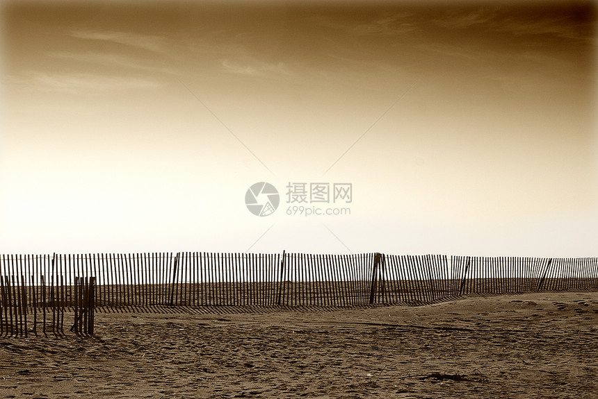 沿卡利弗罗尼亚沙滩和棕色山地地带的木栅栏图片