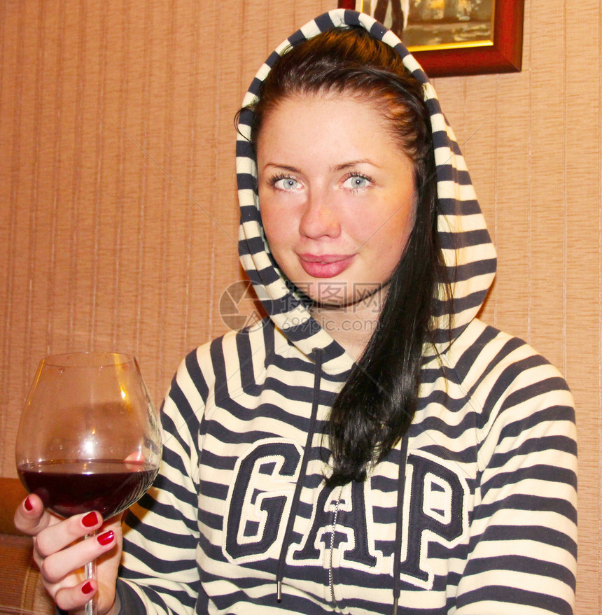 一个年轻女子 喝了一杯红酒派对食物女性玫瑰女士享受玻璃酒杯衣服相机图片