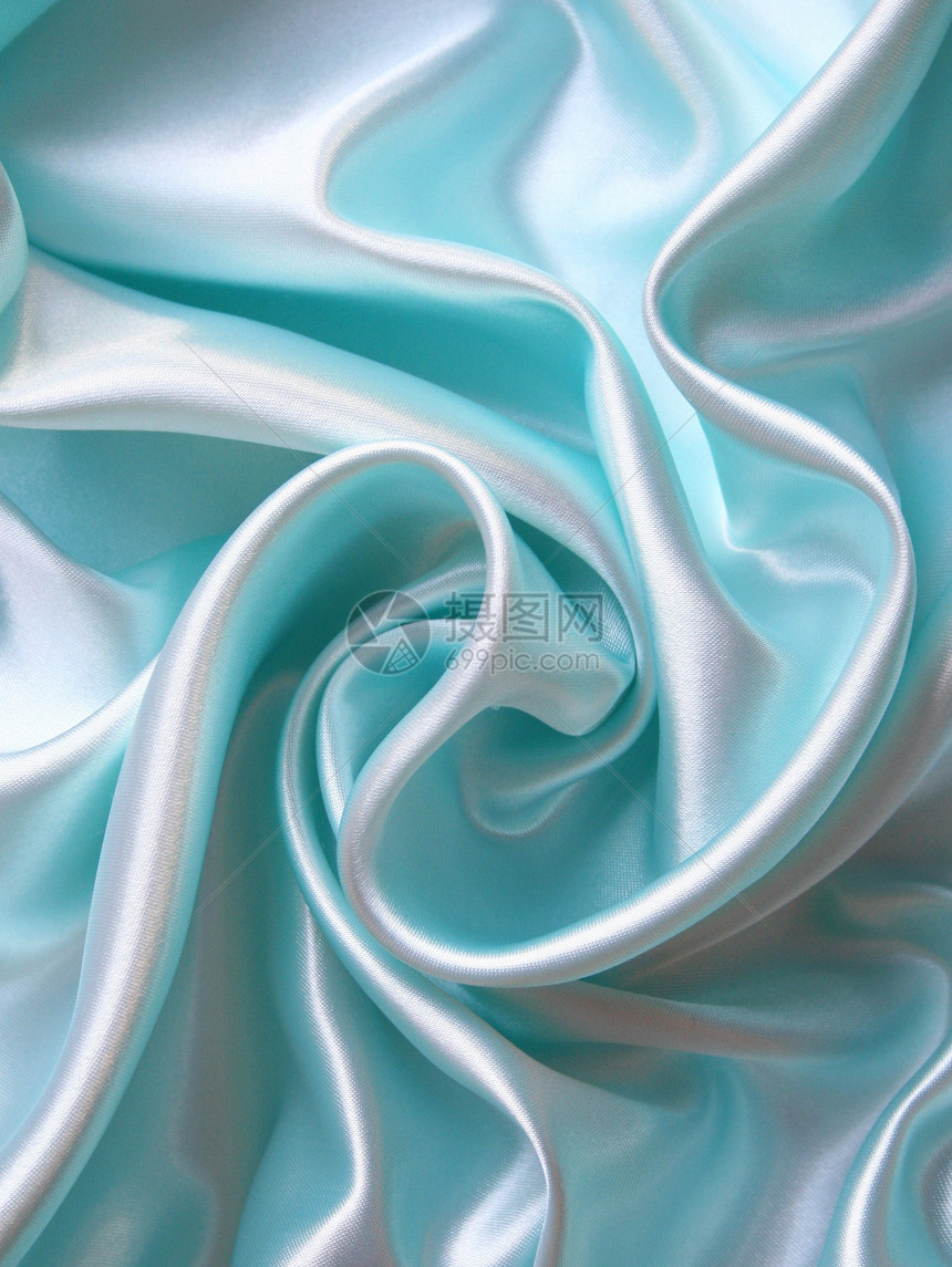 平滑优雅的蓝色丝绸作为背景生产纺织品折痕织物曲线投标感性版税银色海浪图片