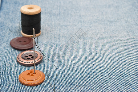 牛仔裤扣扣和针针宏观按钮棉布牛仔布材料衣服接缝织物帆布纤维背景图片