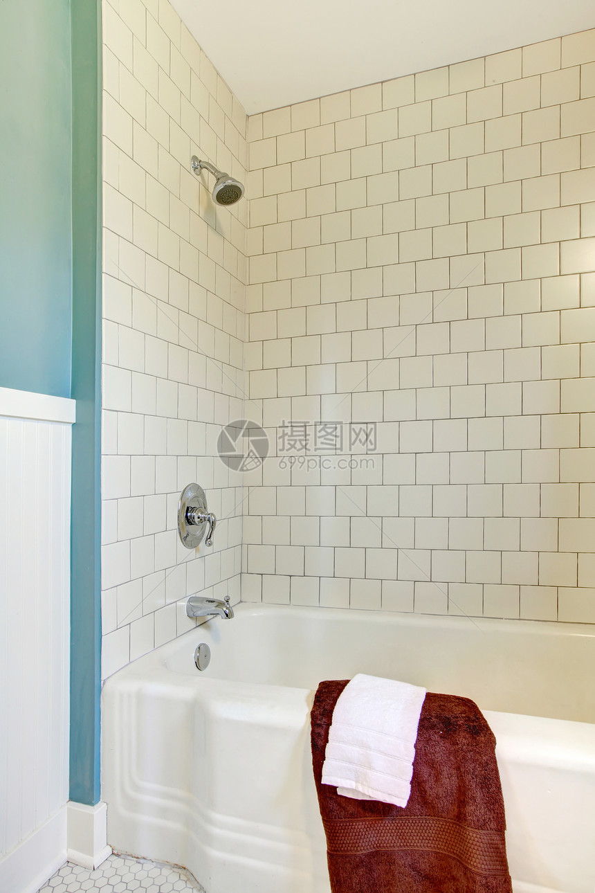 用白色经典瓷砖和蓝色墙的浴缸和浴缸图片