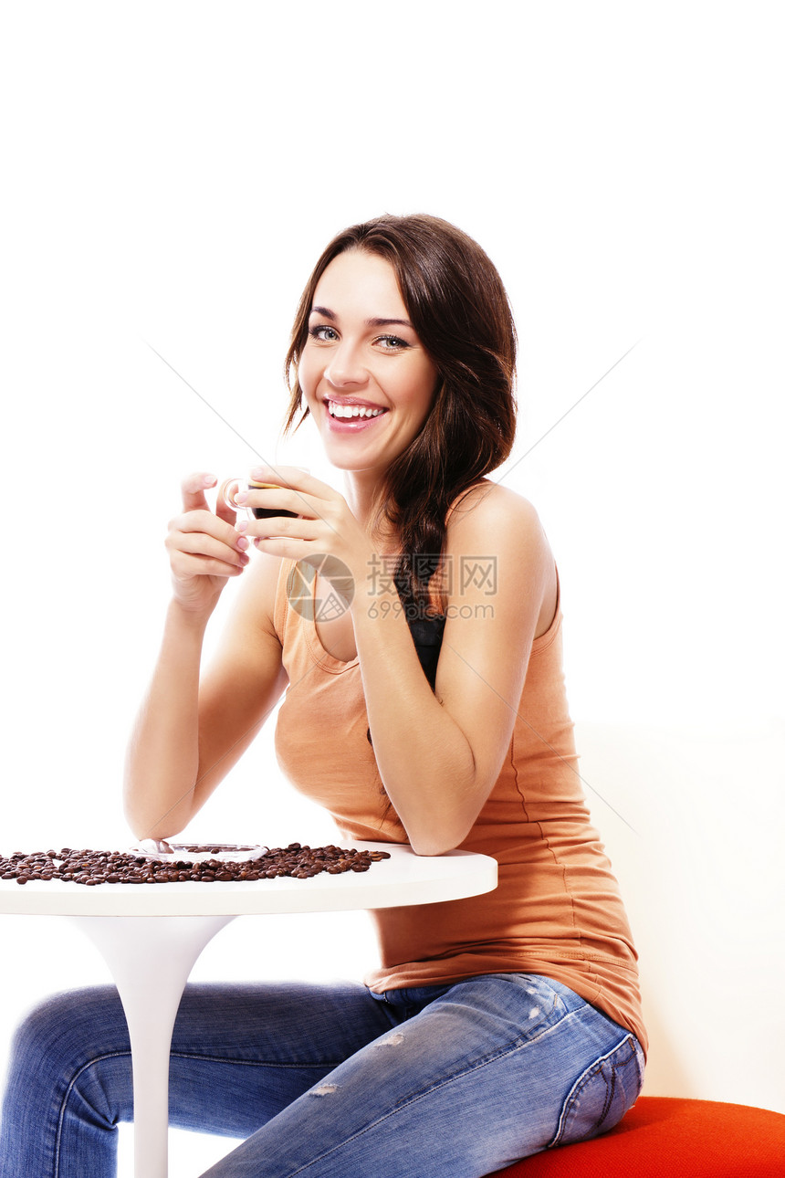 美丽的快乐的女士坐在桌子上 喝着咖啡和咖啡图片
