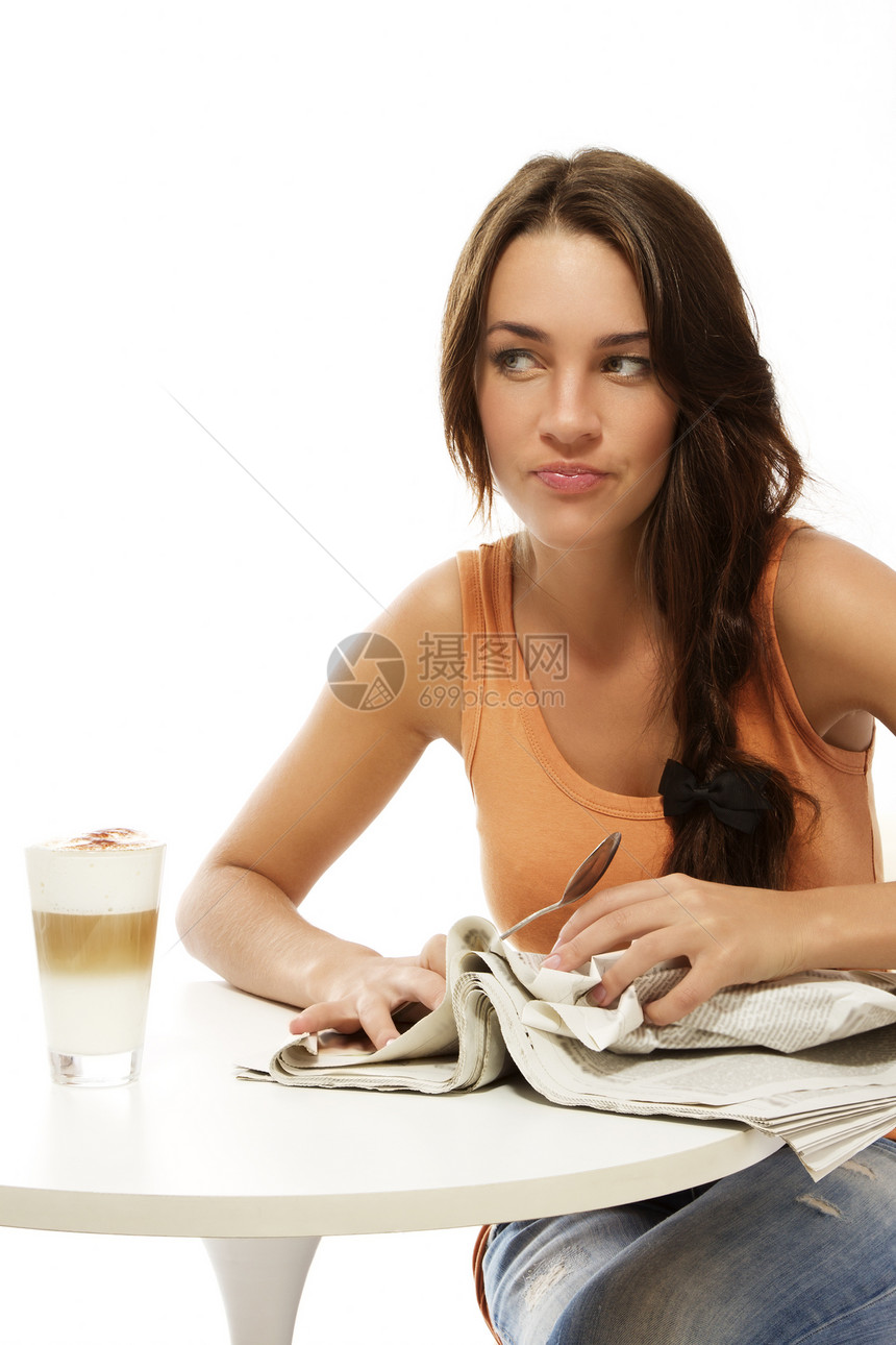 心烦意乱的年轻女子 报纸和餐桌上的拿铁马奇亚托图片
