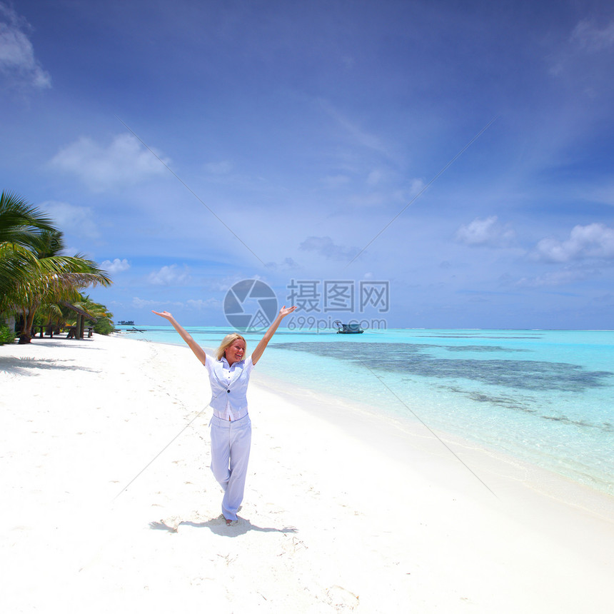 海洋海岸上快乐的女商务人士阳光蓝色天空旅行热带套装假期女性商务女孩图片