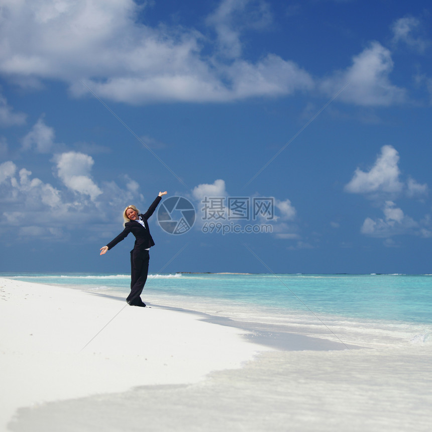 海洋海岸上快乐的女商务人士海滩蓝色套装太阳海浪工人假期金发女郎热带微笑图片