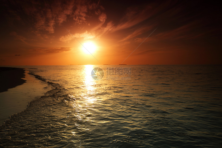 日落在海中地平线海滩场景太阳反射海浪橙子天空热带旅行图片