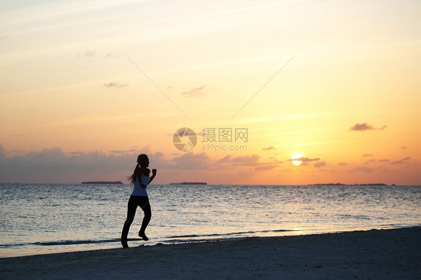 妇女逃亡日落练习运动天空慢跑海洋海滩支撑波浪女士图片