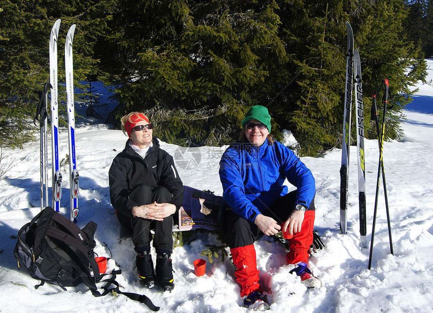 滑雪太阳绿色女士红色树木男人黑色晴天蓝色微笑图片