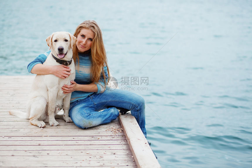 带狗的女孩女性草地微笑白色拥抱闲暇蓝色训练宠物猎犬图片