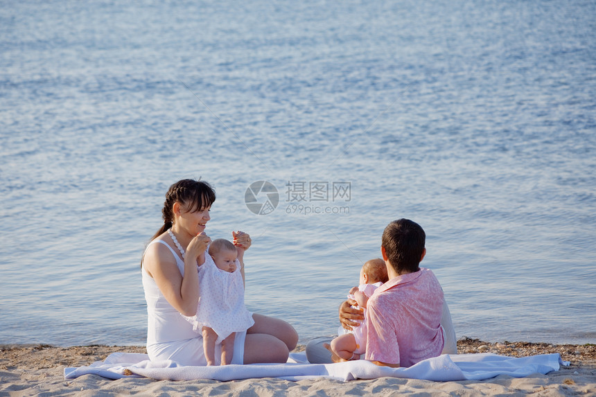 家庭在海滩上母亲蓝色假期生活微笑育儿双胞胎母性拥抱童年图片