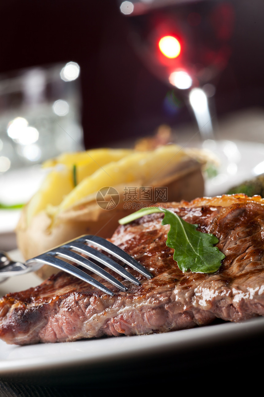 叉在烤牛排上条纹午餐反射刀具食物叶子绿色牛肉玻璃美食图片